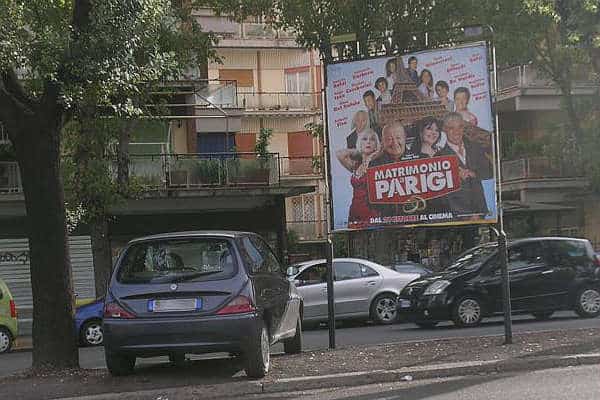 Uno stendardo con una locandina di un film all'interno di un parcheggio